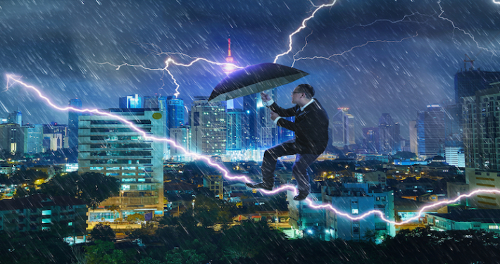 young businessman with umbrella against thunderstorm overcoming challenges and crisis SBI 301985594